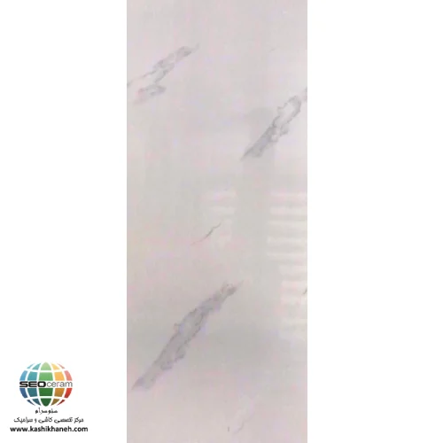 سرامیک مروارید براق صدیق سرام آباده معرفی سرامیک مروارید براق صدیق سرام آباده سرامیک مروارید براق صدیق سرام آباده یکی از محصولات زیبا و کاربردی برای پوشش دیوارهای داخلی ساختمان است که با الهام از سنگ مرمر طبیعی طراحی شده است. همانطور که در تصویر سرامیک مروارید براق صدیق سرام آباده مشاهده میشود، زمینه سفید روشن همراه با رگههای طوسی ملایم، ظاهری طبیعی، آرام و لوکس ایجاد کرده که بهراحتی با انواع سبکهای معماری هماهنگ میشود. این محصول برای افرادی مناسب است که به دنبال ایجاد فضایی روشن، تمیز و مدرن هستند اما در عین حال تمایل دارند از طرحهای شلوغ و پرجزئیات استفاده نکنند. استفاده از رنگ سفید در کنار خطوط طبیعی سنگ، باعث شده این سرامیک در محیطهای مختلف مانند آشپزخانه، سرویس بهداشتی، حمام، راهرو و حتی دیوار سالن پذیرایی جلوهای چشمنواز ایجاد کند. این محصول در ابعاد 60×30 سانتیمتر تولید شده و یکی از اندازههای استاندارد برای نصب روی دیوار محسوب میشود. اندازه مناسب آن باعث میشود نصب سرامیک با سرعت بیشتری انجام شده و میزان پرت مصالح نیز کاهش پیدا کند. علاوه بر این، بدنه خاک قرمز محصول استحکام مناسبی برای استفاده در دیوارهای داخلی فراهم کرده و به دلیل کیفیت مطلوب مواد اولیه، دوام قابل قبولی در شرایط معمول ساختمان دارد. لعاب براق نیز باعث افزایش زیبایی سطح سرامیک شده و نور محیط را بهتر منعکس میکند. نتیجه این ویژگیها، فضایی روشنتر، بزرگتر و دلنشینتر خواهد بود که حس تمیزی و نظم را به محیط منتقل میکند.