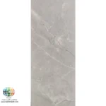 سرامیک ناپل براق کاشی صدیق سرام آباده معرفی سرامیک ناپل براق کاشی صدیق سرام آباده سرامیک ناپل براق کاشی صدیق سرام آباده یکی از محصولات زیبا و کاربردی برای پوشش دیوارهای داخلی ساختمان است که با الهام از بافت سنگ طبیعی طراحی شده و ظاهری آرام، مدرن و لوکس به محیط میبخشد. همانطور که در تصویر محصول مشاهده میشود، زمینه طوسی روشن همراه با رگههای طبیعی و نامنظم، جلوهای نزدیک به سنگهای طبیعی ایجاد کرده است. این طراحی باعث میشود فضای داخلی بدون شلوغی بصری، حس نظم، آرامش و زیبایی بیشتری پیدا کند. استفاده از چنین طرحی در سالهای اخیر به یکی از محبوبترین انتخابهای معماران و طراحان داخلی تبدیل شده است، زیرا علاوه بر ظاهر زیبا، با بسیاری از سبکهای معماری هماهنگی دارد. ابعاد 80×40 سانتیمتر این سرامیک باعث میشود تعداد بندهای اجرا کاهش پیدا کند و سطح دیوار یکپارچهتر دیده شود. این ویژگی علاوه بر افزایش زیبایی، سرعت نصب را نیز بیشتر میکند. بدنه خاک قرمز این محصول کیفیت مناسبی برای استفاده در دیوارهای داخلی فراهم کرده و به دلیل ساختار استاندارد خود، انتخابی اقتصادی و کاربردی برای پروژههای ساختمانی محسوب میشود. همچنین لعاب براق به کار رفته روی سطح سرامیک، نور محیط را منعکس کرده و باعث میشود فضا روشنتر، بزرگتر و دلبازتر به نظر برسد.