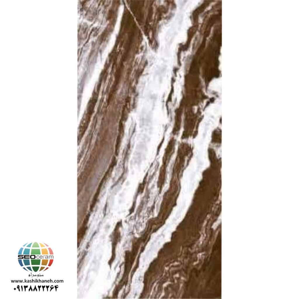 سرامیک خاک قرمز آراگون تیره براق ماهان سرام | 120×60 سرامیک خاک قرمز آراگون تیره براق ماهان سرام یکی از مدل‌هایی است که به دلیل طرح سنگی خاص و قابلیت اجرای بوک مچ، می‌تواند در طراحی فضاهای لوکس و مدرن مورد توجه قرار بگیرد. سرامیک خاک قرمز آراگون تیره براق ماهان سرام در ابعاد 120×60 سانتی‌متر ارائه شده و ظاهر آن ترکیبی از طیف‌های قهوه‌ای، خاکی، سفید و رگه‌های طبیعی است. تضاد میان قسمت‌های تیره و روشن باعث شده سطح محصول از حالت یکنواخت خارج شود و جلوه‌ای نزدیک به سنگ‌های طبیعی با رگه‌های پرتحرک داشته باشد. ویژگی مهم سرامیک خاک قرمز آراگون تیره براق ماهان سرام، بوک مچ بودن آن است. در اجرای بوک مچ، دو یا چند قطعه سرامیک در کنار یکدیگر قرار می‌گیرند تا رگه‌ها و نقوش آنها در امتداد یکدیگر قرار گرفته و یک تصویر بزرگ‌تر و پیوسته روی دیوار ایجاد شود. به همین دلیل، سرامیک خاک قرمز آراگون تیره براق ماهان سرام را می‌توان گزینه‌ای مناسب برای ایجاد دیوار شاخص در لابی ساختمان، فروشگاه، فضای تجاری، سرویس بهداشتی، حمام و سایر فضاهای دکوراتیو دانست. انتخاب یک سرامیک مناسب برای دیوارهای دکوراتیو، فقط به رنگ و کیفیت سطح محدود نمی‌شود. زمانی که هدف ایجاد یک دیوار شاخص و متفاوت باشد، طرح، جهت قرارگیری رگه‌ها، ابعاد قطعات و نحوه اجرای آن اهمیت بسیار بیشتری پیدا می‌کند.